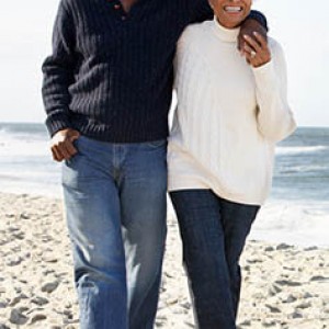 Photo of doctor and spouse walking on beach