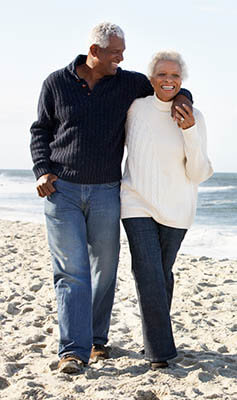 Photo of doctor and spouse walking on beach