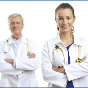 Photo of two doctors standing together, one young and the other ready to retire.